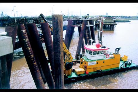Engineers are lifted to work on pilings for the Berth 4 restraint dolphins last month. Note the operational approach bridge to Berths 1, 2 and 3 and the spur to Berth 4.